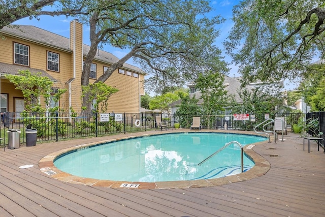 community pool featuring a deck and fence