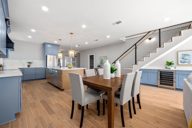 1007 Payne Ave, Austin, TX 78757 - dining space with visible vents, light wood-style floors, wine cooler, and stairway