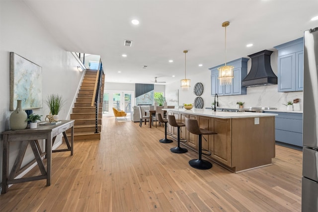 1007 Payne Ave, Austin, TX 78757 - kitchen with light countertops, recessed lighting, open floor plan, visible vents, and custom exhaust hood