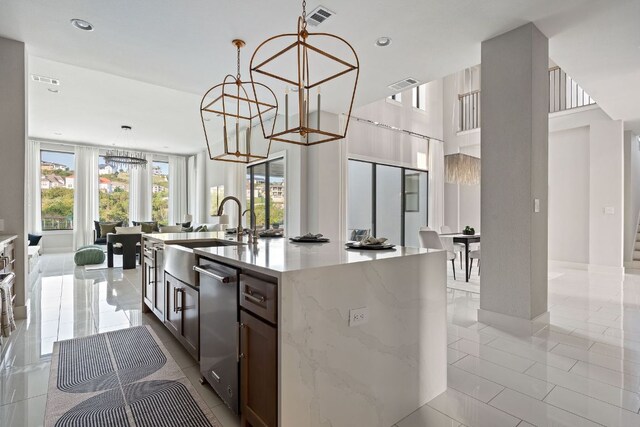 kitchen with visible vents, a center island with sink, a chandelier, a sink, and dishwasher