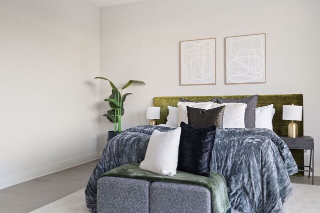 bedroom featuring baseboards and wood finished floors