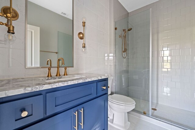 full bathroom featuring vanity, toilet, tiled shower, and tile walls