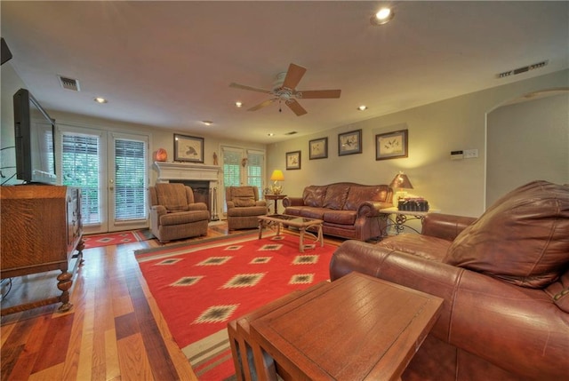 living room with visible vents, arched walkways, a ceiling fan, and a healthy amount of sunlight