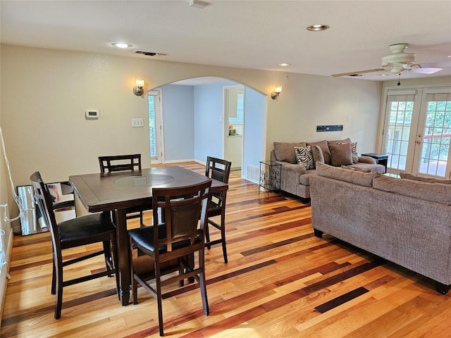dining space featuring arched walkways, a ceiling fan, recessed lighting, and light wood-type flooring