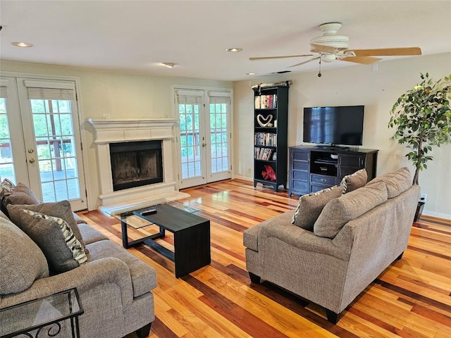 living area with french doors, ceiling fan, wood finished floors, and a healthy amount of sunlight