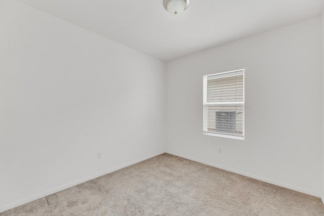 unfurnished room featuring baseboards and carpet flooring