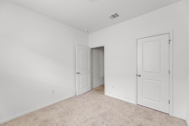 unfurnished bedroom featuring carpet floors, baseboards, and visible vents