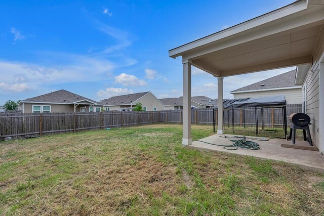 view of yard featuring a fenced backyard, a patio area, and a residential view