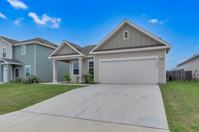 ranch-style house with board and batten siding, an attached garage, concrete driveway, and a front yard