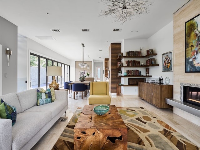 living room featuring a tiled fireplace and visible vents