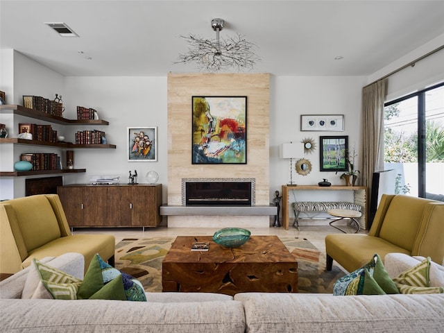 living room with a tile fireplace, wood finished floors, and visible vents