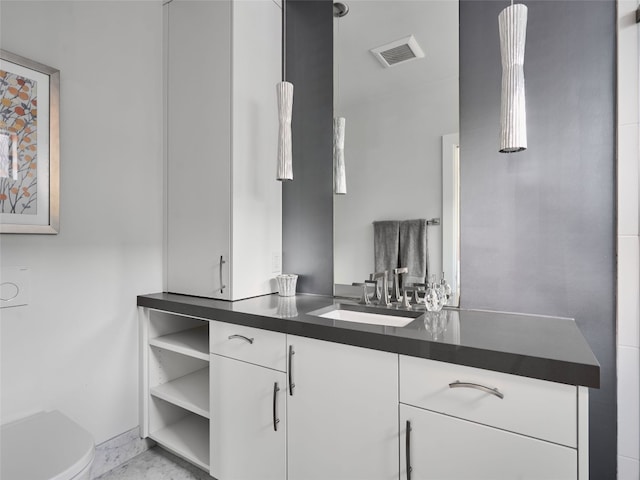 bathroom featuring visible vents, toilet, and vanity