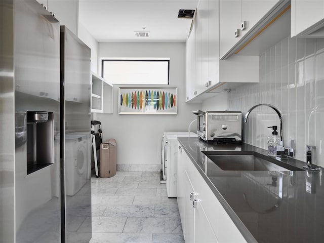 kitchen featuring visible vents, tasteful backsplash, a toaster, baseboards, and white cabinets