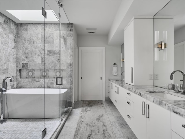 bathroom with a sink, a freestanding tub, double vanity, and visible vents