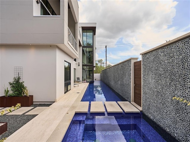 view of swimming pool with an in ground hot tub, a fenced backyard, and a patio area