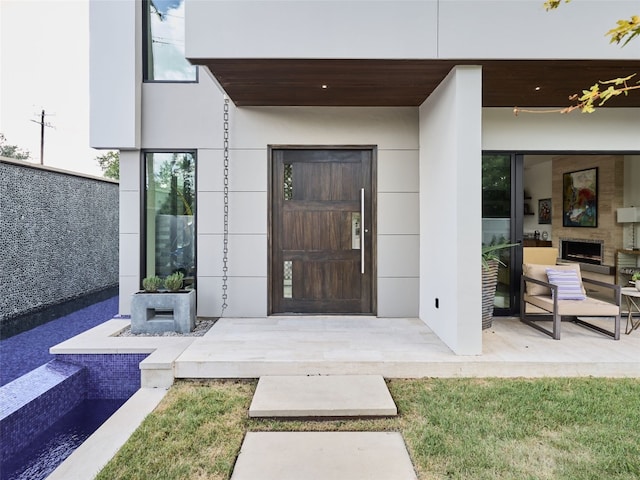 view of exterior entry with a patio and stucco siding