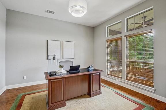 office space featuring baseboards, visible vents, and light wood-type flooring