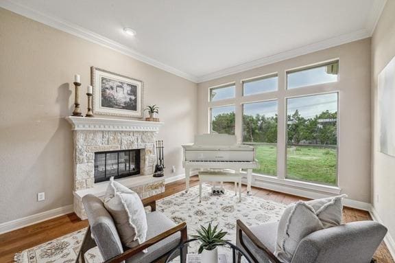 living room with crown molding, baseboards, wood finished floors, and a fireplace