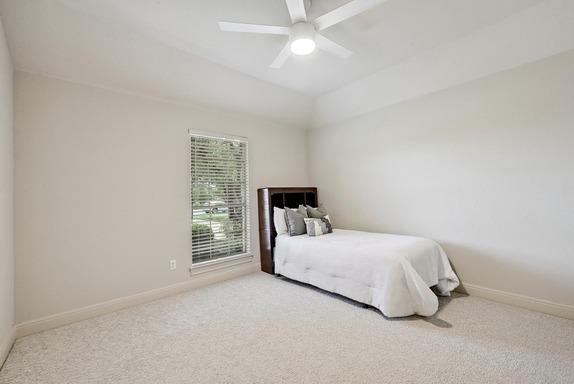 bedroom with a ceiling fan, baseboards, and carpet
