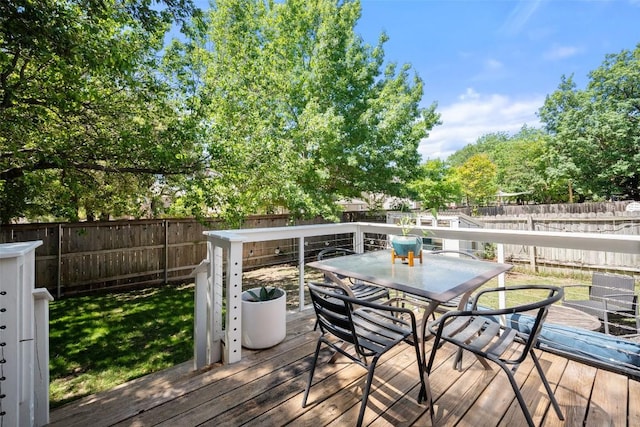 deck featuring outdoor dining area and a fenced backyard