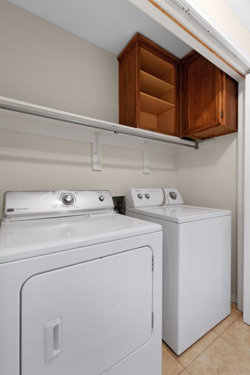 1809 Woodland Dr, Cedar Park, TX 78613 - washroom with cabinet space, independent washer and dryer, and light tile patterned flooring