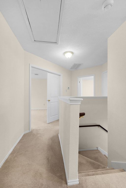 1809 Woodland Dr, Cedar Park, TX 78613 - hallway with light colored carpet, attic access, baseboards, and an upstairs landing