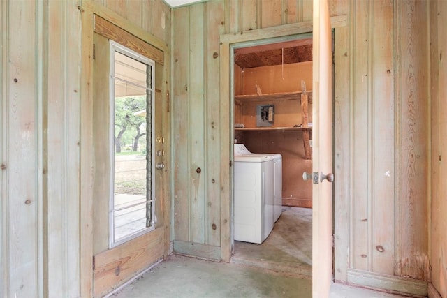 laundry area with wooden walls, separate washer and dryer, laundry area, and plenty of natural light
