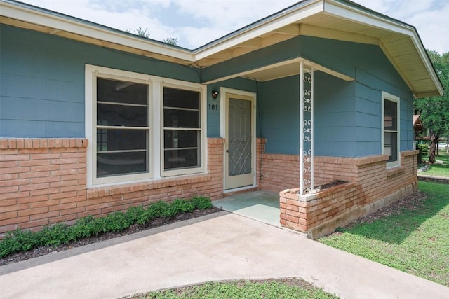 property entrance featuring brick siding