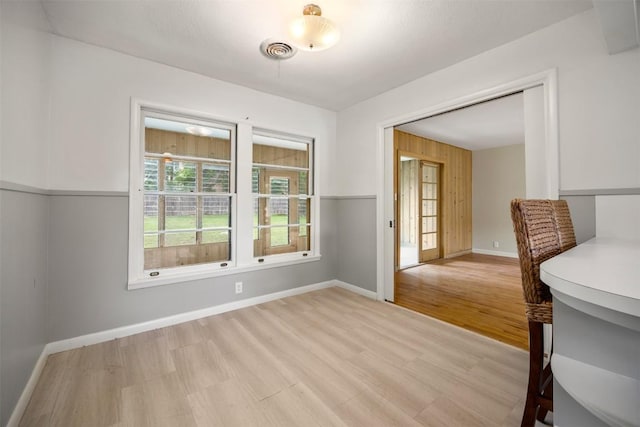 empty room with baseboards, visible vents, and light wood-style floors