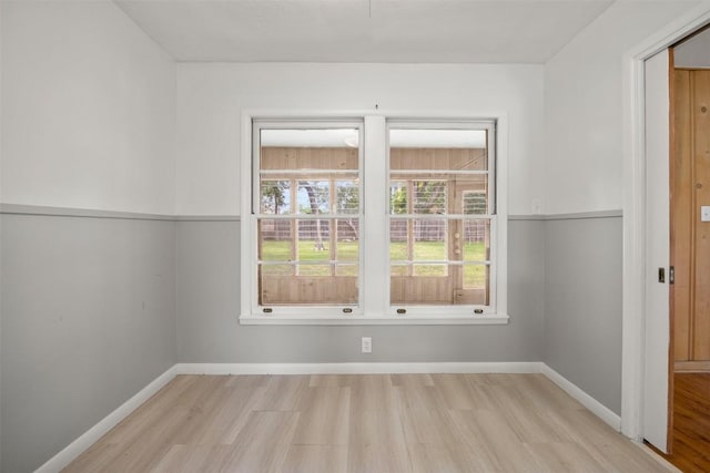 unfurnished room featuring baseboards and wood finished floors