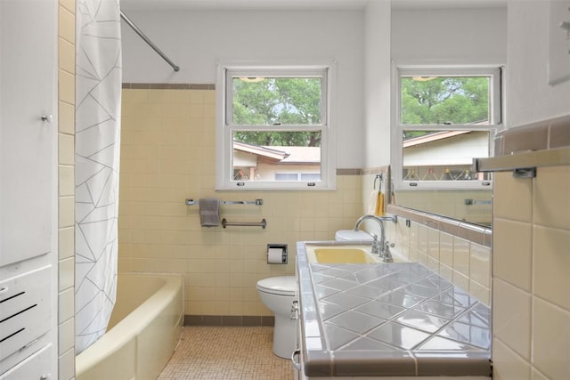 full bath featuring tile walls, plenty of natural light, tile patterned floors, and toilet