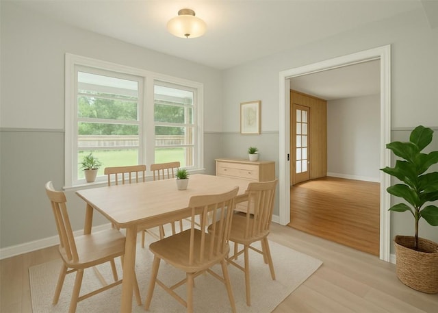 dining room with baseboards, a healthy amount of sunlight, and light wood-type flooring