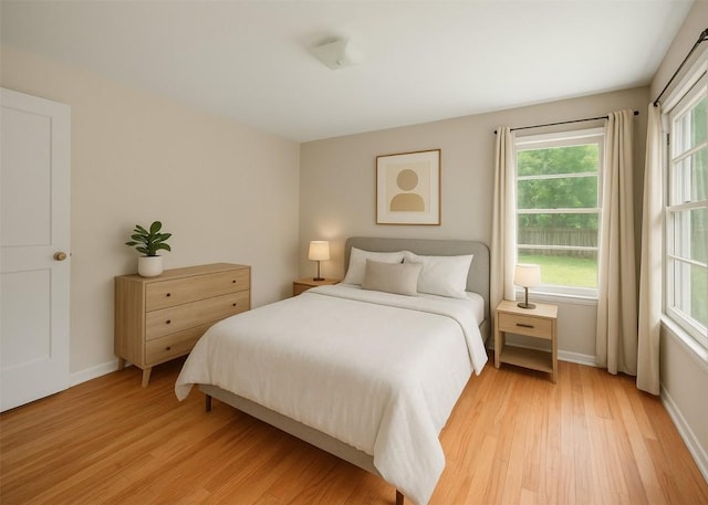 bedroom featuring baseboards and light wood finished floors