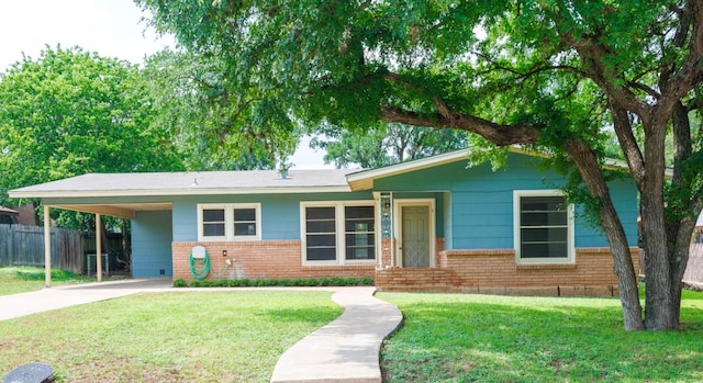 ranch-style house featuring brick siding, a front lawn, fence, and driveway