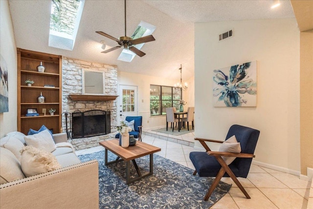 living area featuring a textured ceiling, visible vents, a fireplace, ceiling fan with notable chandelier, and light tile patterned flooring