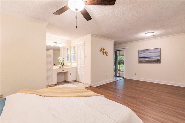 bedroom with crown molding, a textured ceiling, and wood finished floors