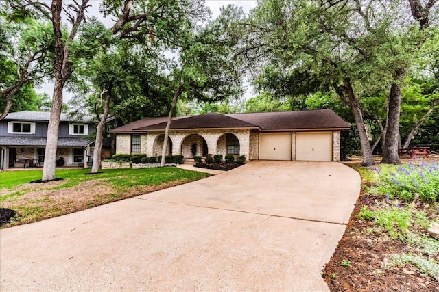 view of front of property with an attached garage, a front lawn, brick siding, covered porch, and driveway
