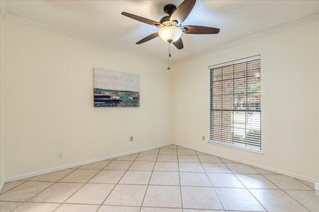 empty room with crown molding, ceiling fan, light tile patterned flooring, and a textured ceiling