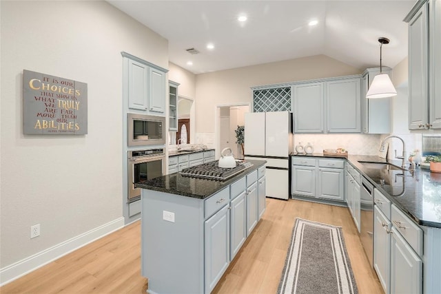 kitchen featuring backsplash, visible vents, a center island, a sink, and stainless steel appliances