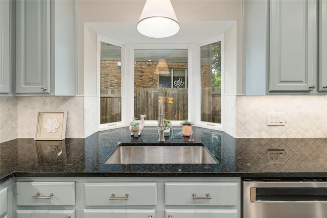 kitchen with a sink, decorative backsplash, dark stone counters, and dishwasher