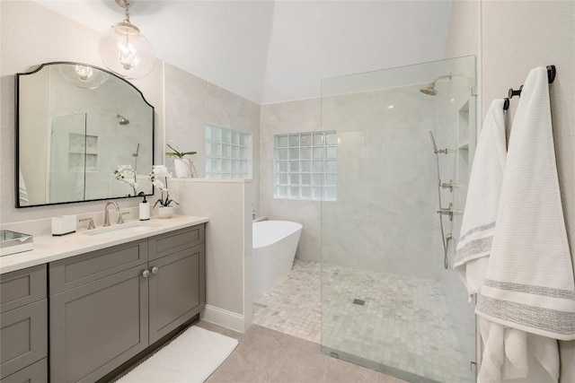 full bathroom featuring a walk in shower, a freestanding tub, tile patterned floors, and vanity