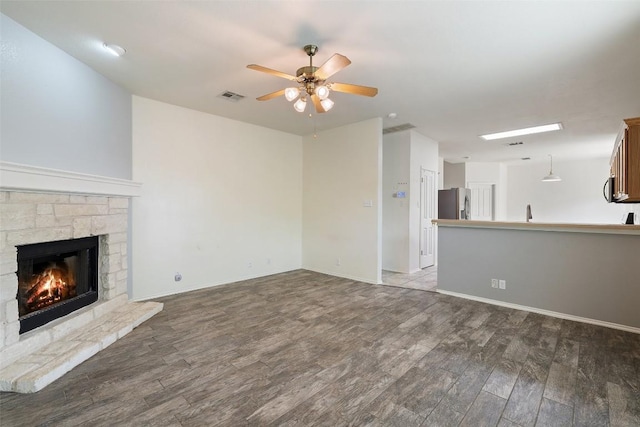 407 N Lori Cir, Bastrop, TX 78602 - unfurnished living room featuring wood finished floors, ceiling fan, a fireplace, and baseboards