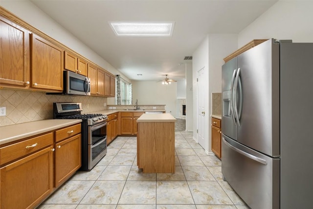 kitchen with light countertops, a ceiling fan, backsplash, and stainless steel appliances