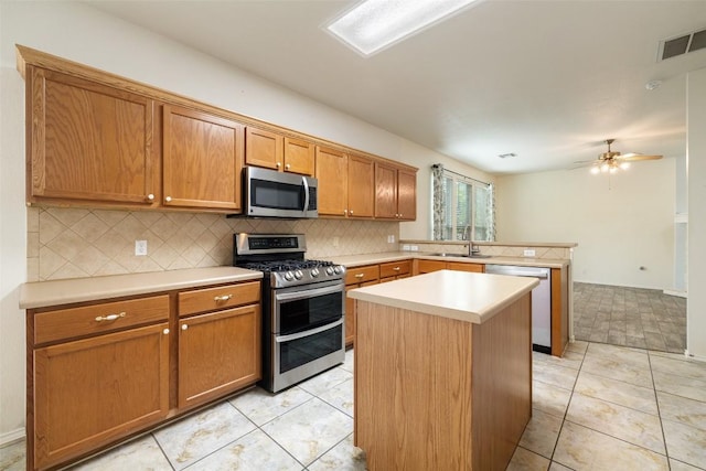 407 N Lori Cir, Bastrop, TX 78602 - kitchen featuring appliances with stainless steel finishes, a sink, a peninsula, and tasteful backsplash