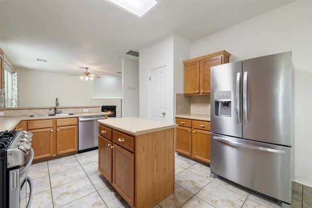 407 N Lori Cir, Bastrop, TX 78602 - kitchen featuring stainless steel appliances, a sink, backsplash, a brick fireplace, and ceiling fan