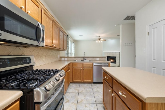kitchen with visible vents, decorative backsplash, a ceiling fan, a sink, and stainless steel appliances
