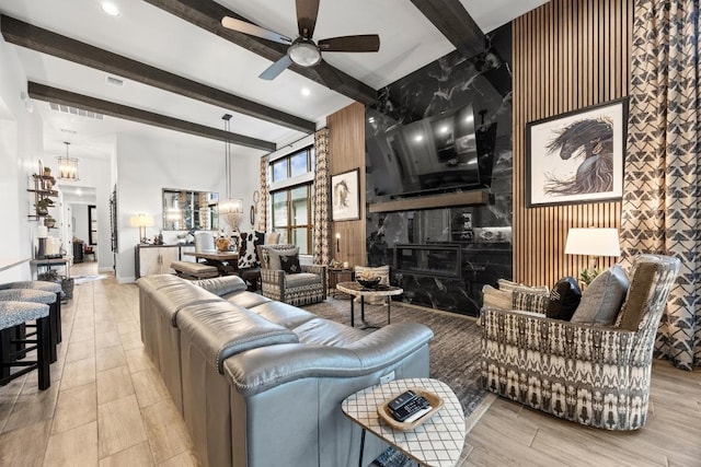 741 Faith Dr, Liberty Hill, TX 78642 - living area with a ceiling fan, beamed ceiling, a chandelier, light wood-style floors, and wooden walls