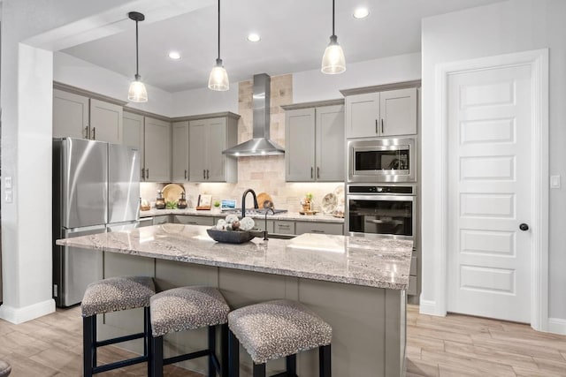 741 Faith Dr, Liberty Hill, TX 78642 - kitchen with appliances with stainless steel finishes, wall chimney range hood, gray cabinets, light wood-style floors, and recessed lighting