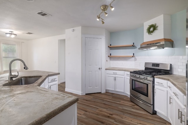 3339 Alexander Valley Cv, Round Rock, TX 78665 - kitchen with stainless steel range with gas cooktop, dark wood-type flooring, tasteful backsplash, white cabinets, and extractor fan