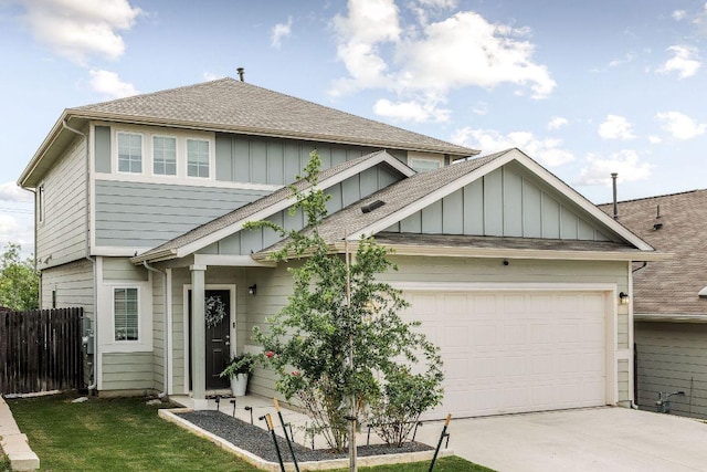 view of front of property with a garage, fence, a shingled roof, board and batten siding, and driveway